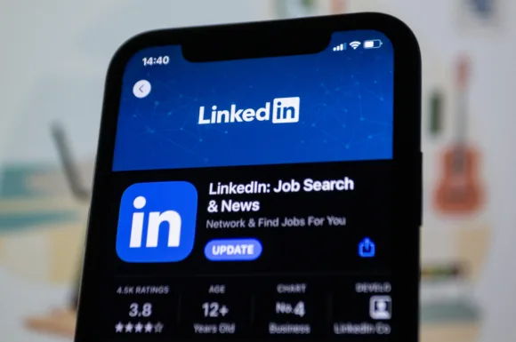 Smartphone che mostra la schermata di aggiornamento dell'app LinkedIn con enfasi sul networking e la ricerca di lavoro, indirizzata agli utenti che desiderano ottimizzare il loro Profilo LinkedIn.
