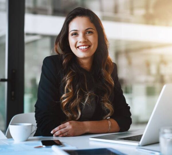 Studentessa felice mentre segue un corso SAP online su laptop, in un ambiente moderno e professionale.