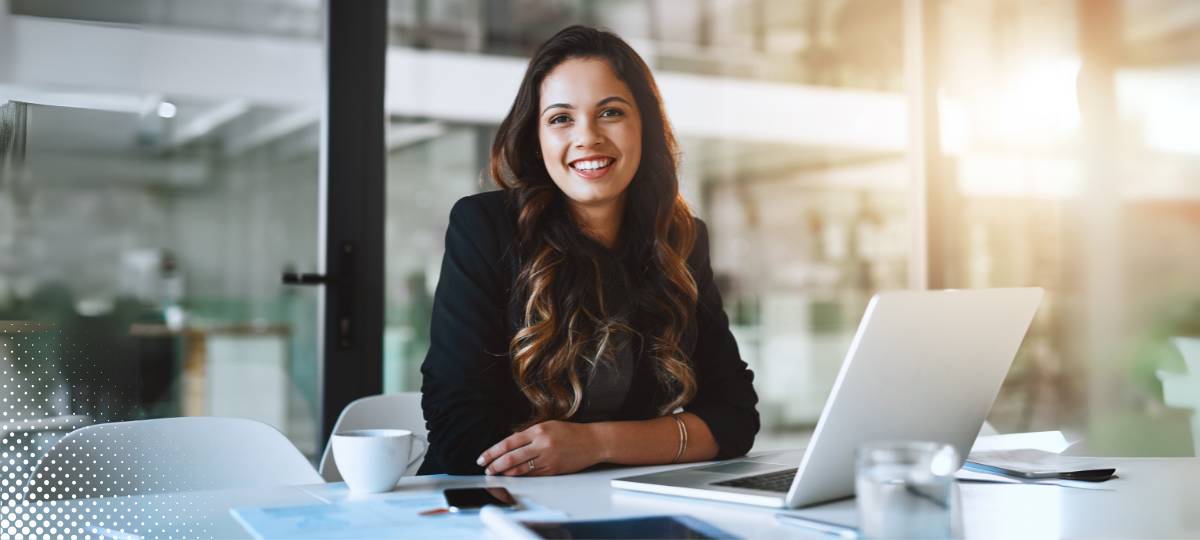 Studentessa felice mentre segue un corso SAP online su laptop, in un ambiente moderno e professionale.